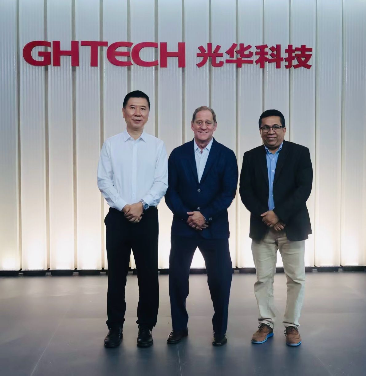 Dr. Mazhar Islam, Dr. Bobby Savoie, and GHTECH Chairman Ren Zheng stand in front of the company's sign during their visit to GHTECH in China.